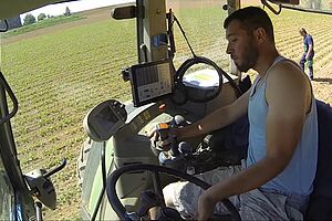 Un homme sur un tracteur dans un champs de betteraves bio