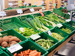 Des légumes sont placés dans des corbeilles pour être vendus dans un magasin.