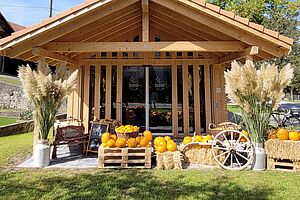 Une maison en bois avec des étalages de légumes. 