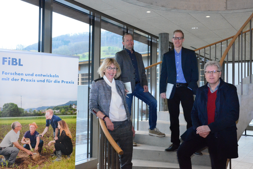 Les quatre personnes mentionnées se tiennent sur un escalier