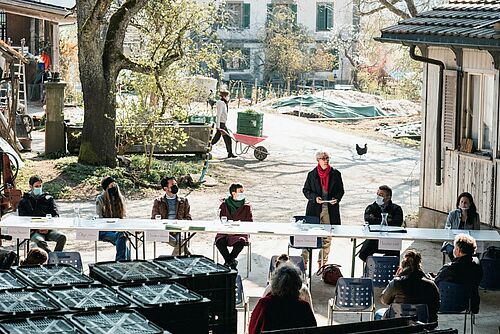 Une table dehors, autour les orateurs