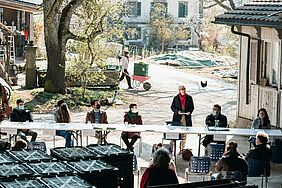 Une table dehors, autour les orateurs