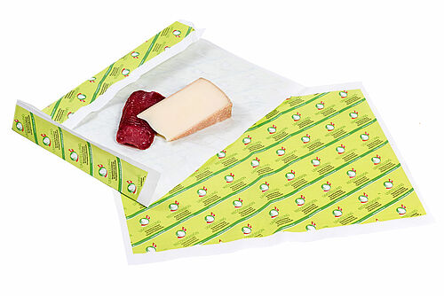 Papier d’emballage  et pièce de viante et un morceau de fromage