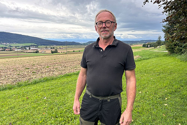 stéphane challandes, agriculteur, pose devant ses parcelles déchaumées.