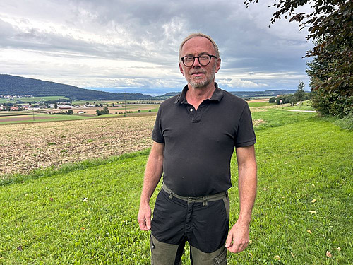 stéphane challandes, agriculteur, pose devant ses parcelles déchaumées.