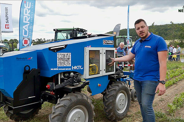 Un homme à l'avant d'un véhicule à traction 4x4 avec machine de sarclage à l'arrière