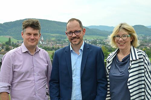 Les trois personnes mentionnées devant des collines