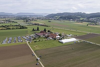 une vue aérienne de la cour avec le parking et les tentes d'exposition.