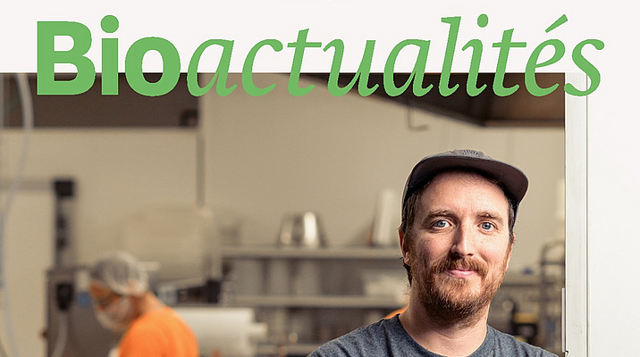 Page de couverture du Bioactualités 10|25: Un homme regarde la caméra, les bras croisés, tandis qu'à l'arrière-plan, une personne travaille sur une installation.