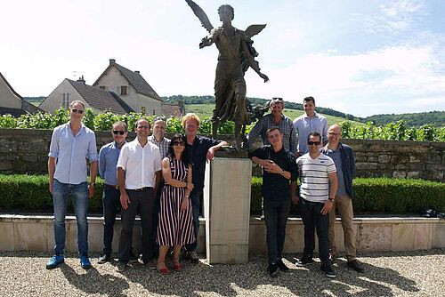 Un groupe d'élèves devant une statue dans la cour d'un château.