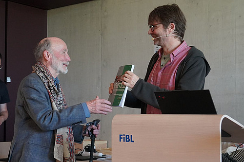 Florian Leiber remet un livre à Otto Schmid en guise de remerciement.