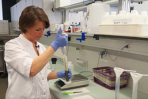 Personne dans le laboratoire avec une pipette.