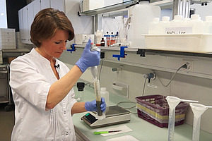 Personne dans le laboratoire avec une pipette.