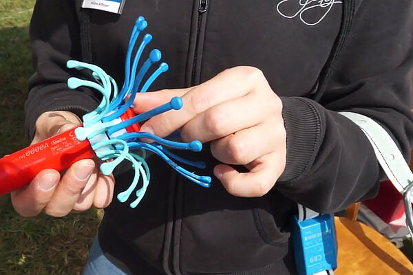 Femme tenant une structure en forme d'araignée dans ses mains