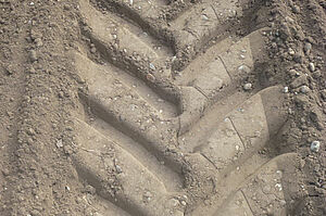des traces profondes de pneus sur un sol fraîchement travaillé