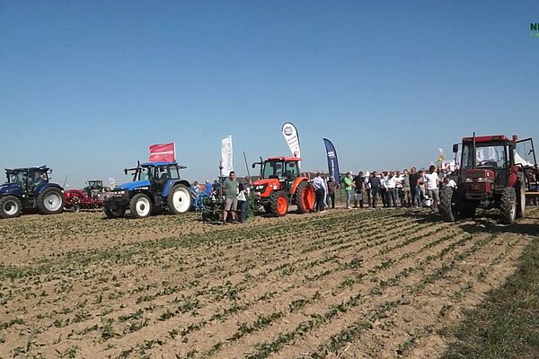 Des tracteurs sur un champs avec des spectateurs