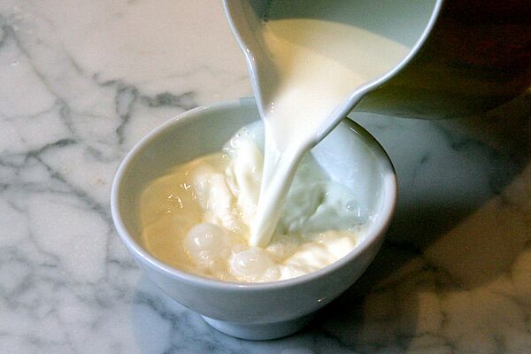 Du lait est versé dans un bol