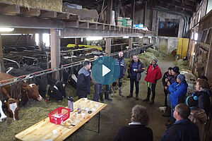 Des agriculteurs autour d'une table dans une étable à bétail