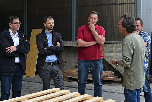 Quatres personnes debout parlent ensemble