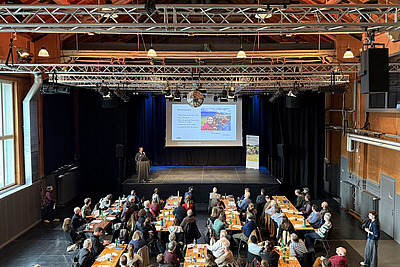 Vue sur le podium et les auditeurs et auditrices.