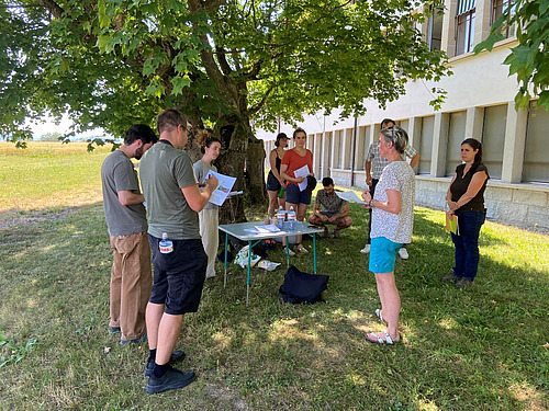 journalistes et chercheurs rassemblés sous un arbre pendant les échanges