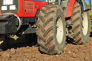  Une vue détaillée des pneus d'un tracteur rouge dans un champ.