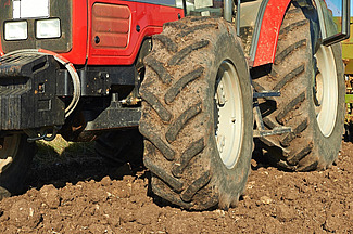  Une vue détaillée des pneus d'un tracteur rouge dans un champ.