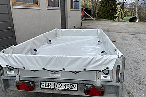 Remorque de transport avec bâche grise.