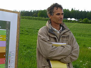 Photo de Nicolas Rossier avec un champ à l'arrière-plan.