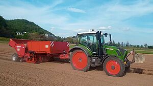 Tracteur avec remorque rouge pendant la plantation