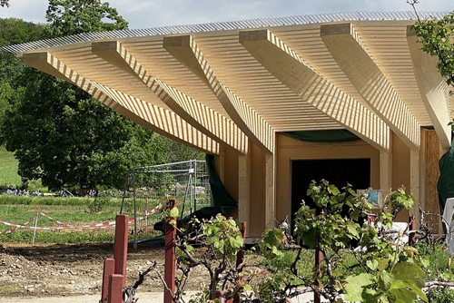 Construction en bois avec une structure de toit en saillie.