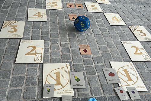 Jeu avec un dé et des cartes numérotées sur le thème du génie génétique.