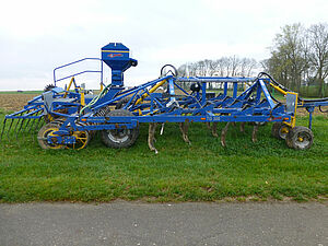 Une grosse machine bleue servant à décaper et gratter le sol.