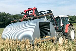 Un tracteur portant une cabane en acier galvanisé