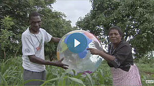 Une femme et un homme tenant un ballon qui ressemble au monde