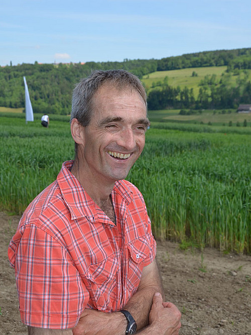 Tracteur et sarcleuse en train de sarcler un très jeune maïs.
Vue aérienne de la 2ème journée nationale des grandes cultures bio.
Portrait de Philippe Tavel.
Portrait de Bernard et Thierry Candaux
Des visiteurs se penchent sur le sol fraîchement