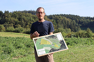 Un homme sur le terrain, un plan à la main.