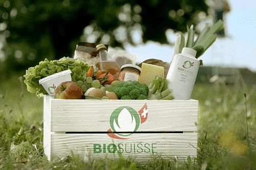 Une caisse avec des legumes et du lait avec le logo de Bio Suisse