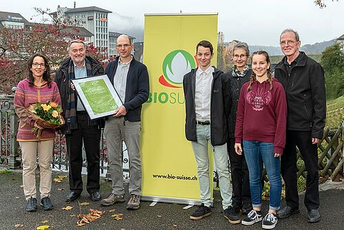 7 personnes devant und affiche jaune avec le logo Bourgeon