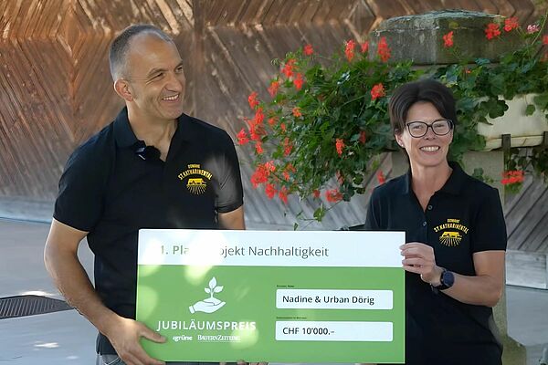 Un homme et une femme tiennent un prix intitulé « 1er prix projet de développement durable ».