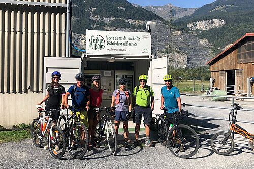 Des cyclistes devant un magasin de ferme
