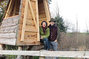 un homme et une femme dans une cahute en bois